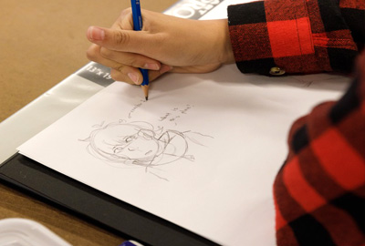 student drawing character on paper