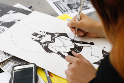 student drawing a character