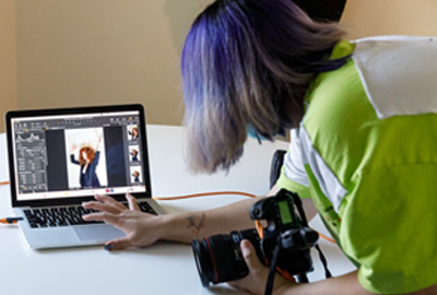 student editing digital photo on laptop compture